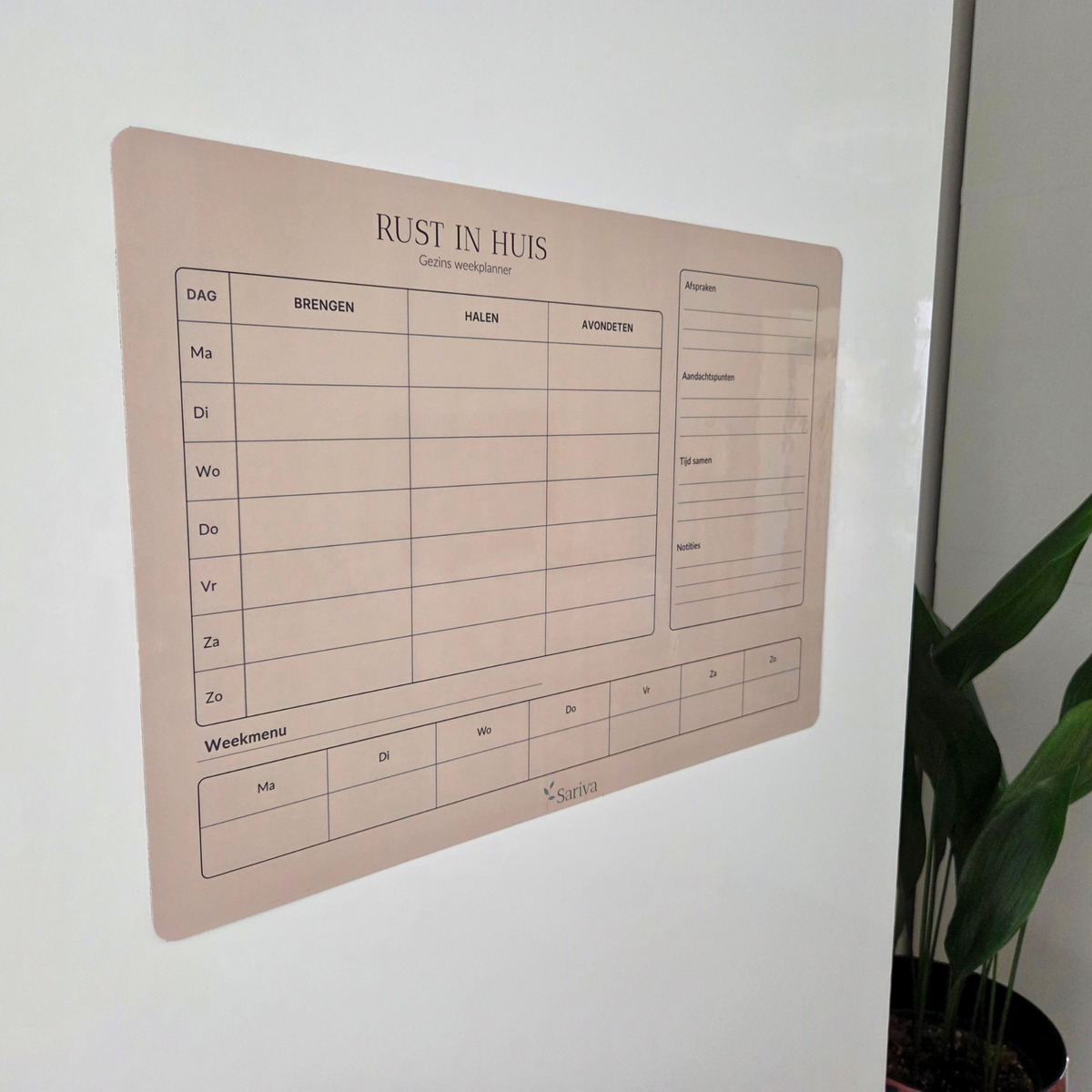 Sariva gezinsweekplanner bevestigd op een gladde kastdeur